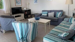 A living room with a sofa, armchairs, a television, and a coffee table. - WATERFRONT VILLA SEAHORSE BAY- HALIKOUNAS (Chalikounas)