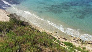 A coastal landscape with clear turquoise waters, sandy beach, and rocky cliffs. - WATERFRONT VILLA SEAHORSE BAY- HALIKOUNAS (Chalikounas)