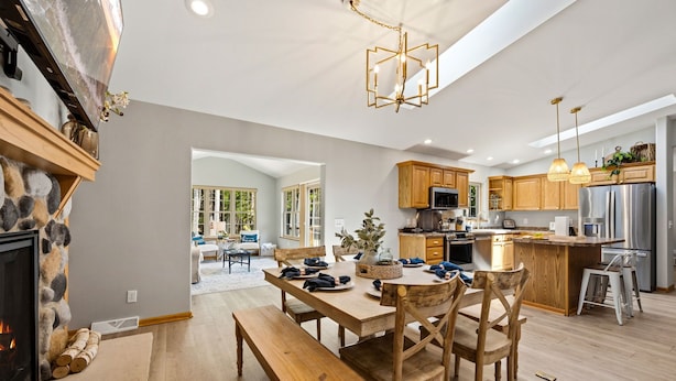 Une cuisine spacieuse avec des meubles en bois, un îlot central et un coin repas comprenant une banquette et des chaises.
