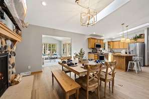 A spacious kitchen with wooden cabinets, a central island, and a dining area with a bench and chairs.