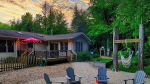 Une cabane dotée d’une terrasse, de meubles de jardin et d’un hamac.