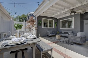 Enjoy a meal al fresco at this outdoor patio, complete with a dining table and comfortable seating area.