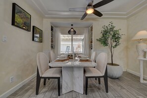 Enjoy meals with family and friends in this cozy dining area, featuring a central table and comfortable seating for four.