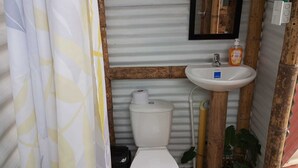 Une petite salle de bain comprenant des toilettes, un lavabo et un miroir.