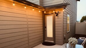 A covered patio with a door, a glass table, and chairs. - Sleeps 9, Pet Friendly, Workspace, Easy Access to Dining and Shops (Meridian)
