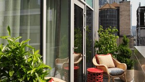 A modern building with large windows and a view of the Empire State Building. - The Fifth Avenue Hotel (New York)