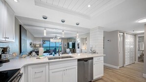 A modern kitchen with white cabinetry, stainless steel appliances, and pendant lighting. - 🌊Beachfront Paradise: 3BR Condo with Pool & Balcony in Indian Rocks Beach-RC 309! (Indian Rocks Beach)
