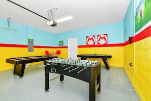 A room with two foosball tables, a projector, and a door marked 'B'.