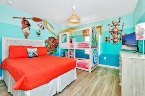 A bedroom with a large bed, two smaller beds, a wardrobe, and a TV.