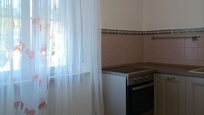 A kitchen with a tiled backsplash, a stove, and a dishwasher. - Renovated apartment in central area (Oristano)