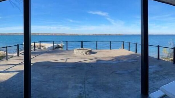 Ein überdachter Außenbereich mit Blick auf das Meer, ausgestattet mit einer Betonplattform und einer Geländer.