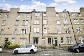 A row of terraced houses with a paved street in front. - Splendid Apartment near Haymarket (Edinburgh)