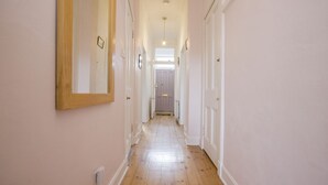 A narrow hallway with wooden flooring and white walls. - Splendid Apartment near Haymarket (Edinburgh)