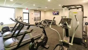 A gym with treadmills, an elliptical, and free weights. - Cozy Studio at the Orlando theme parks Neighborhood (Kissimmee)