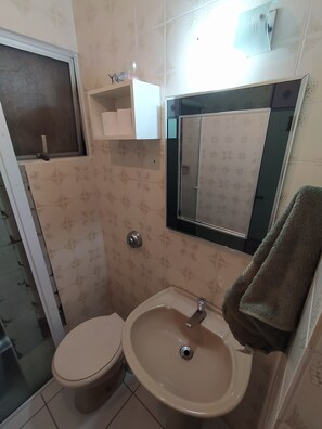 Chuveiro, secador de cabelo, toalhas de banho, papel higiênico