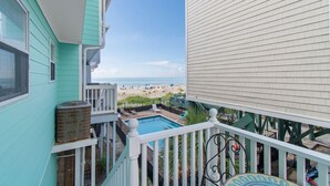 Varanda com vista para uma praia e piscina.