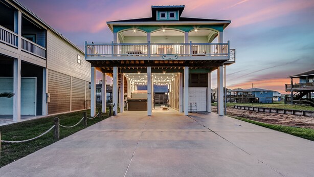 A beachfront hotel with a covered entrance, multiple balconies, and a view of the beach.