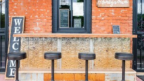 A bar with a 'Welcome' sign, a menu board, and a 'Homegrown' sign. - Beard and Lady Inn (Chester)