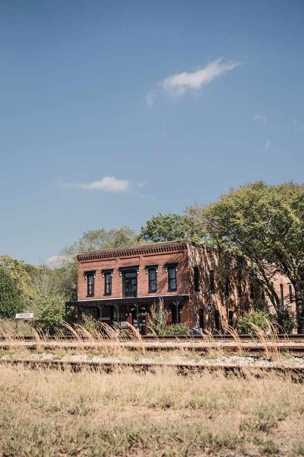 A historic brick building with a porch and a sign reading "Chester" in front.