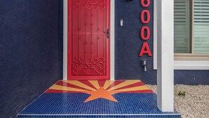 Eine rote Tür mit dekorativem Design, eine Wand mit der Aufschrift '600A' und ein Eingang mit Fliesen in Sternenmuster.