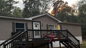 Uma casa móvel térrea com varanda da frente, escadas e uma decoração em forma de estrela vermelha.