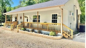 A single-story house with a porch, a small attached garage, and a fenced yard.