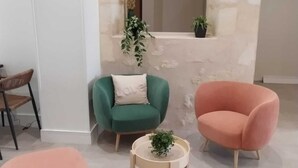 Ein modernes Wohnzimmer mit zwei Sesseln, einem runden Couchtisch und einem kleinen Blumentopf.