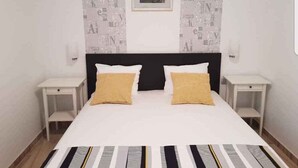 A neatly arranged bedroom with a large bed, two bedside tables, and a framed picture on the wall. - Holiday apartment with sea view and terrace (Orebić)