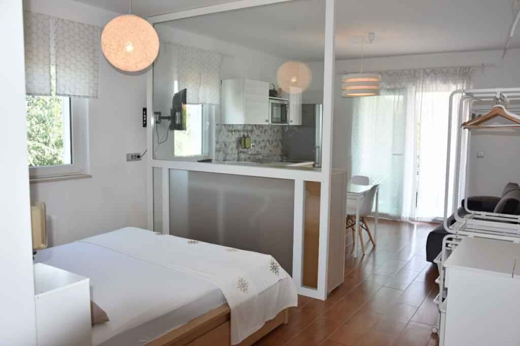 Een compacte hotelkamer met een bed, een kitchenette, een zithoek en een badkamer.