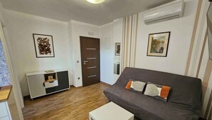 Un salon moderne avec un canapé gris, une table basse blanche et un parquet en bois.