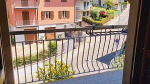 A balcony with a view of a residential street, buildings, and a hilly landscape. - -Le Carillon- Romantic and cozy Suite with Jacuzzi 2 steps from Bergamo (Sorisole)