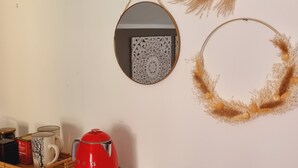 A kitchen area with a white countertop, a red kettle, and decorative wall hangings. - -Le Carillon- Romantic and cozy Suite with Jacuzzi 2 steps from Bergamo (Sorisole)
