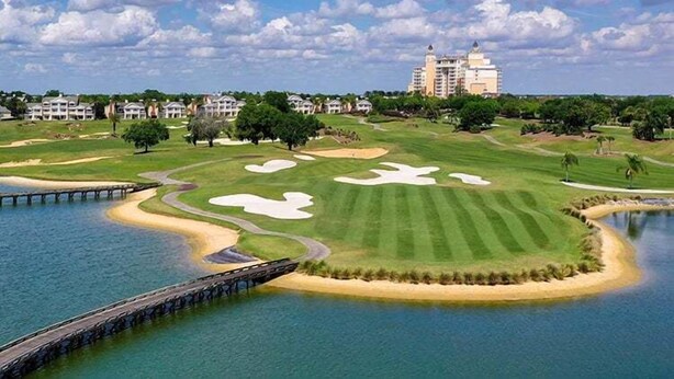 A golf course with bunkers, a water body, and a bridge. - Reunion 3BR Townhouse with Private Patio (Kissimmee)