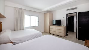 A hotel room with two beds, a TV on a wooden dresser, a window with curtains, and a door. - Fantastic Family Villa on the best Beach in Cancun (CancÃºn)