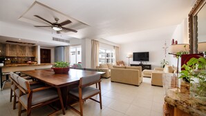 A modern living room with a dining area, a kitchen, and a balcony with curtains. - Fantastic Family Villa on the best Beach in Cancun (CancÃºn)