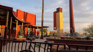 An outdoor seating area with tables and chairs, a bicycle, and a water feature.