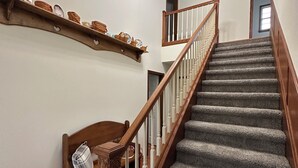 A staircase with wooden railings and carpeted steps leading to an upper floor.