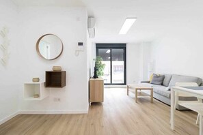 Ein modernes Wohnzimmer mit einer Couch, einem Couchtisch und einem runden Spiegel an der Wand.