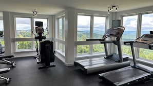 Un gimnasio con equipo de cardio, máquinas de pesas y una cinta de correr.
