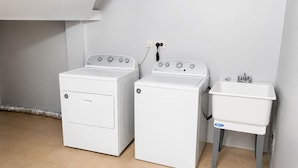 Ein Waschraum mit zwei Waschmaschinen und einem Waschbecken.