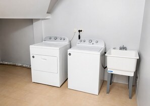 A laundry area with two washing machines and a sink.