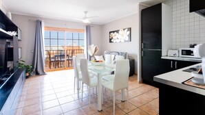 A modern kitchen with a dining area, a large window, and a view of the outdoors. - 21 C Apartamento Las Bouganvillas (Costa Adeje)