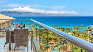 A balcony with wicker furniture and a view of the ocean.
