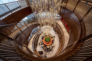 A grand, circular atrium with a central seating area, high ceilings, and a chandelier. - CYNN XANADU Hotel Chengdu (Chengdu)