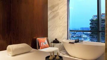 Bathroom with a bathtub and city view.