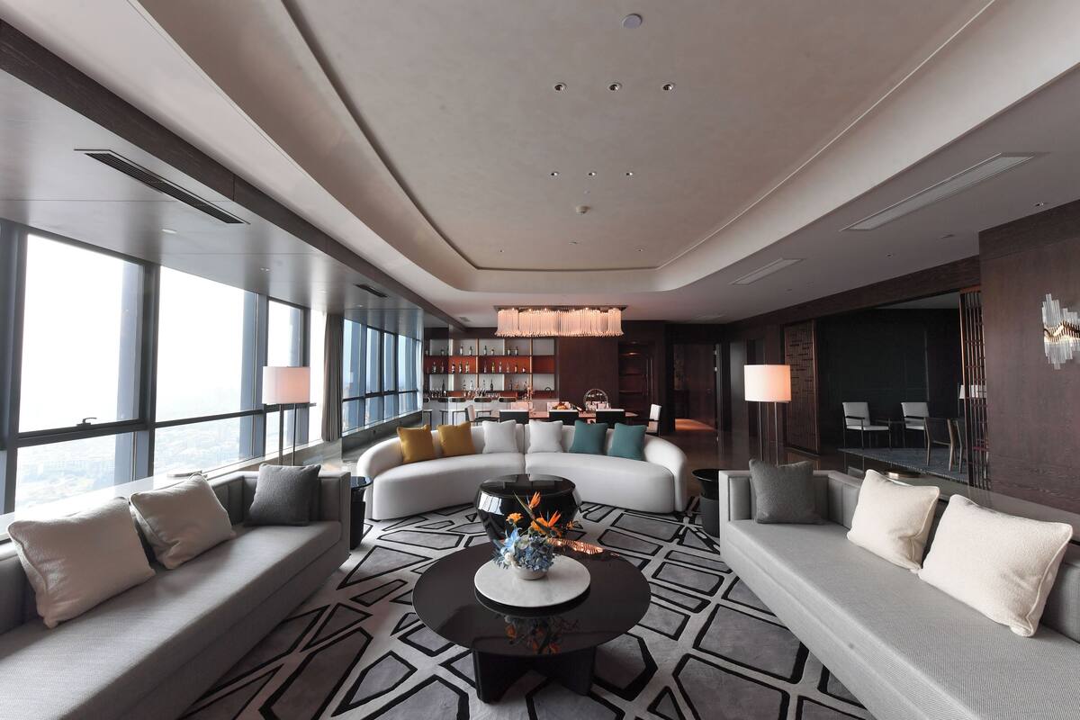A modern living room with a sofa, a coffee table, and a large window.