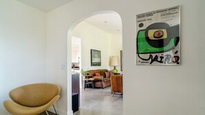 Ein modernes Wohnzimmer mit einem braunen Sessel, einer Couch und einem Bild an der Wand.