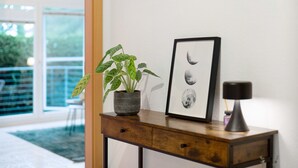 A wooden console table with a potted plant, a framed picture of the moon, and a lamp. - Apartment "City Ravensburg" with Balcony and Wi-Fi (Ravensburg)