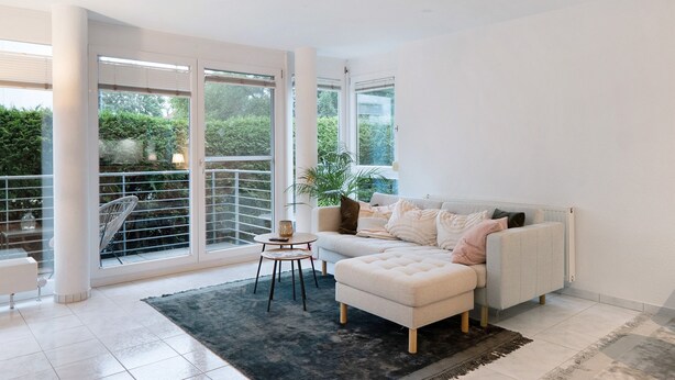 A modern living room with a sofa, ottoman, and a small table. - Apartment "City Ravensburg" with Balcony and Wi-Fi (Ravensburg)