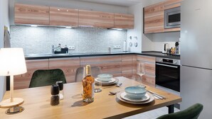 A modern kitchen with wooden cabinets, a built-in microwave, and a stainless steel refrigerator. - Apartment "City Ravensburg" with Balcony and Wi-Fi (Ravensburg)